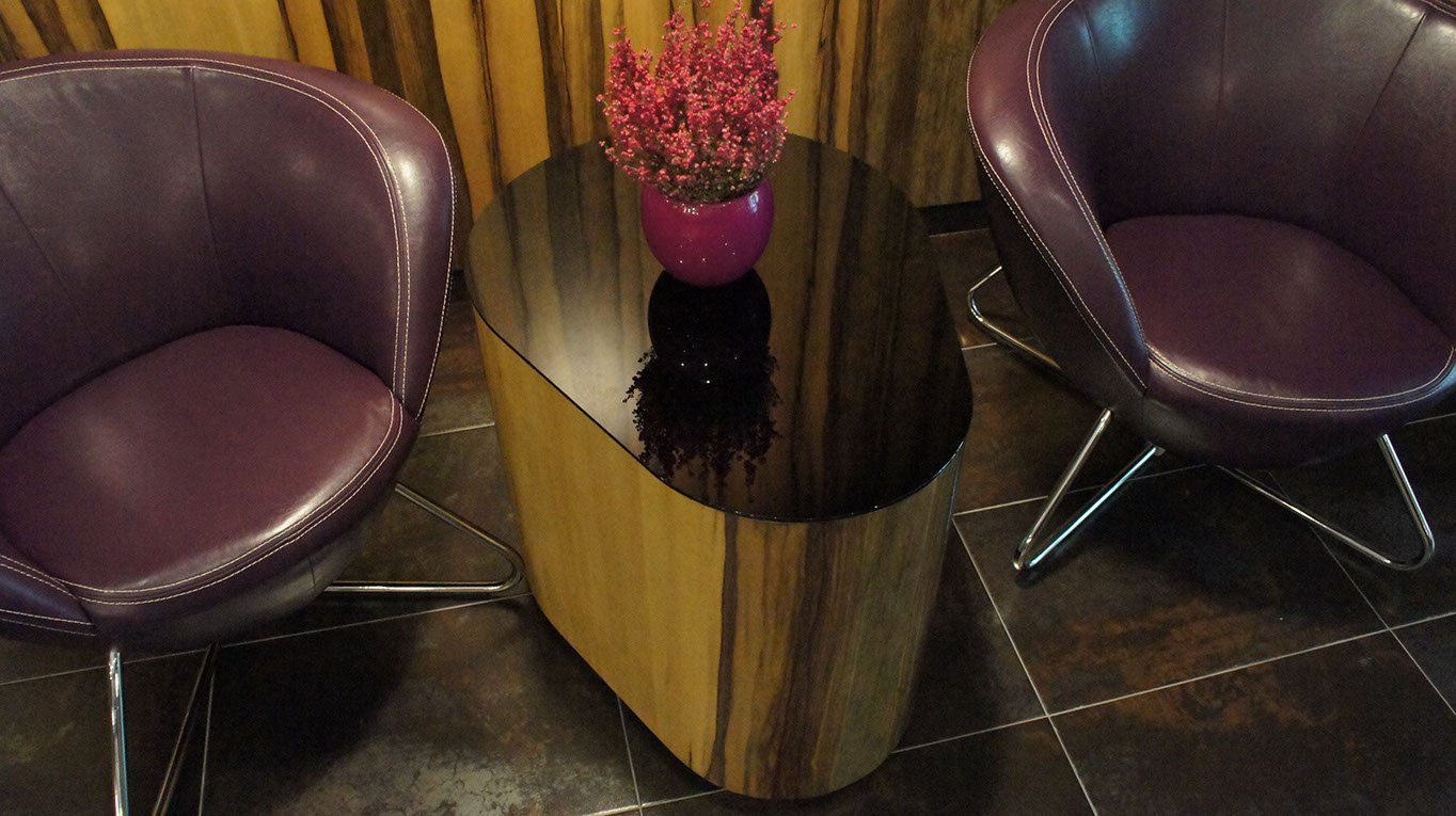 Wygodne fotele i stylowy stolik na kawę, gazetę czy kwiaty. poczekalnia w recepcji hotelowej