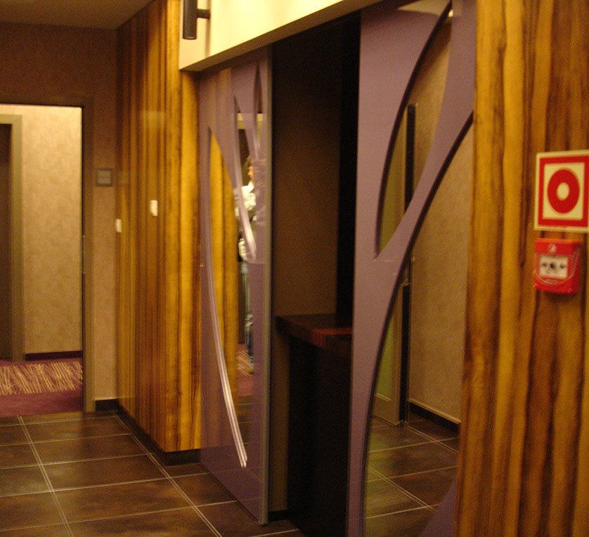 Wejście do szatni hotelowej, drzwi rozsuwane z ażurami lustrzanymi