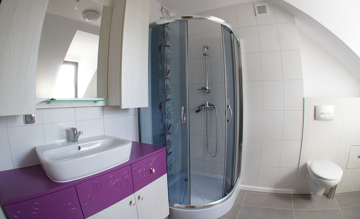 Wykonana przez firmę Tucano Polska łazienka, białe wnętrze z fioletowymi akcentami. Nowoczesny styl wnętrza