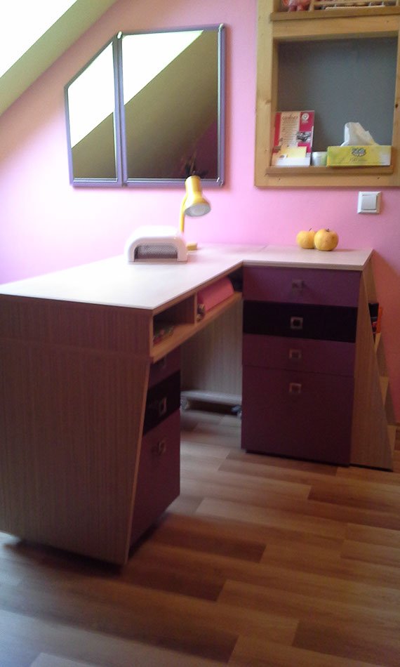 Biurko w pokoju dziecięcym w fioletowym kolorze, dalej widoczne lustro docięte do skosów na poddaszu