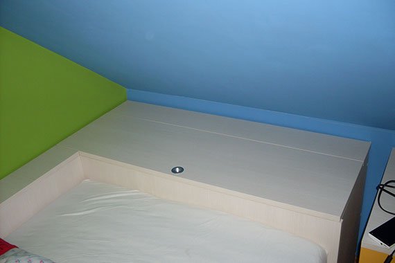 Widok łóżka dla dziecka na poddaszu, najwyższej jakości wyfrezowane meble dopasowane do pomieszczenia